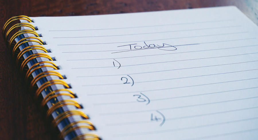 A spiral notebook that has a man holding a pen and making a checklist